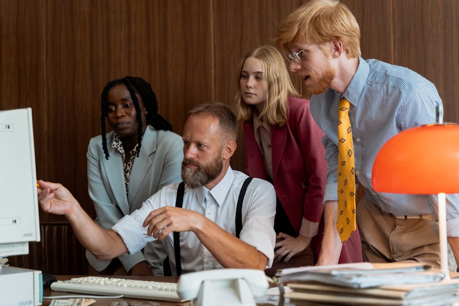 Vintage-style office meeting with diverse team examining computer screen.
