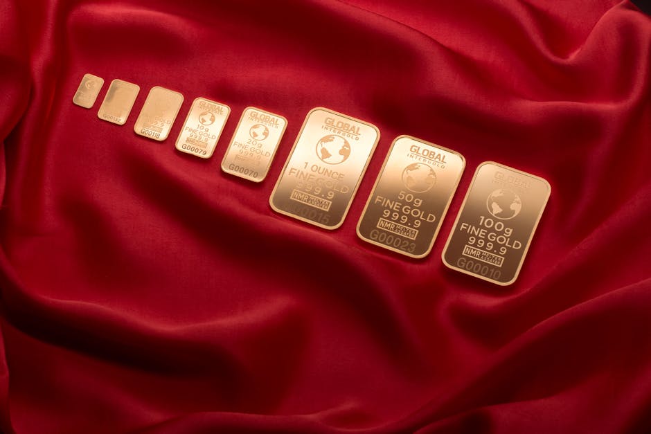 Array of fine gold bars displayed on rich red fabric, symbolizing wealth and luxury.
